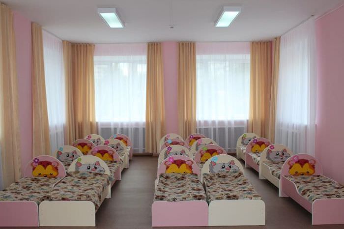 Lysebrune gardiner på vinduerne i børns soveværelse
