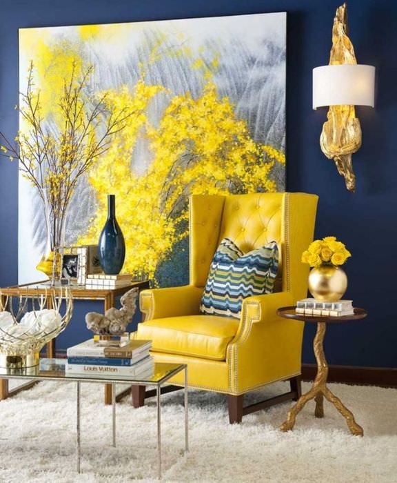 כורסה צהובה על קיר כחול עם ציור