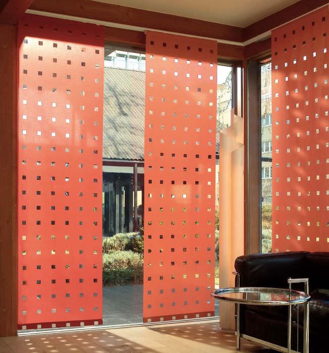 Červené japonské závesy s perforáciou na veľkom okne obývačky