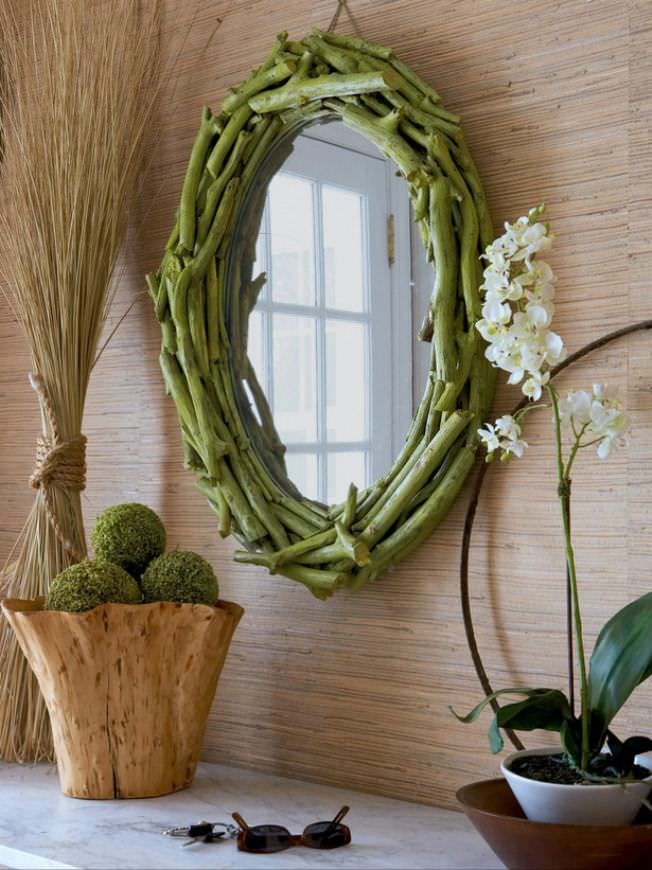 Domácí rám vyrobený z větví na oválném zrcadle