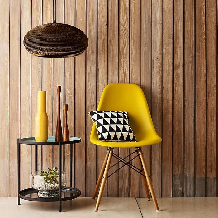Žltá stolička a drevený obklad steny