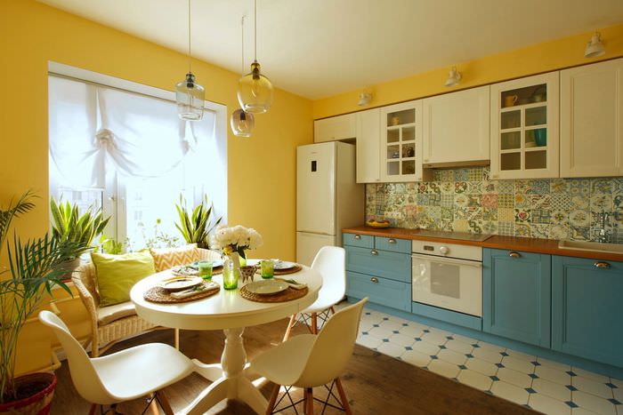 Hvidt og blåt sæt i et køkken med gule vægge
