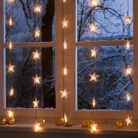 Γιρλάντα αστέρων στο παράθυρο το βράδυ