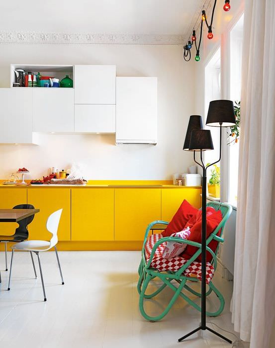 Жълти шкафове от кухненския комплект на фона на бяла стена