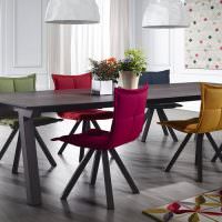 Mjuka stolar i olika färger i matsalen-köket i ett privat hus