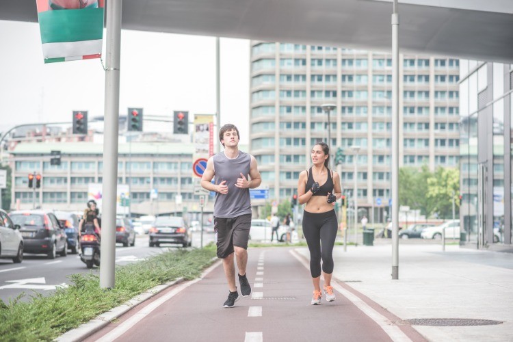 ungt par, der jogger i byen, kan effektivt forbrænde flere kalorier gennem træning og intensitet