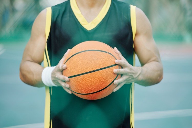 sporty basketballspiller med bold på banen
