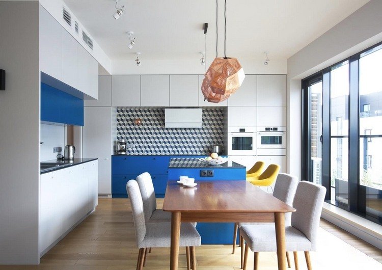pladsbesparende forlængelse af en blå køkkenø med et spisebord i træ og køkkenstole