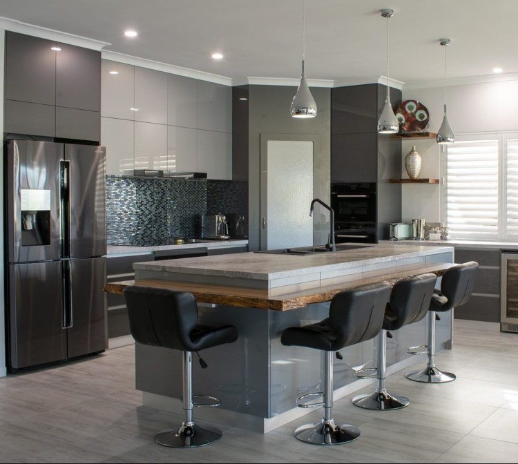 Moderne køkken i højglans med en køkkenø med en Threse lavet af genbrugstræ og en vask i sort og en bordplade af natursten