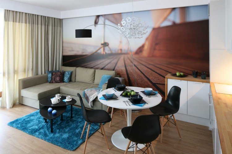 lille-stue-spisestue-foto-tapet-landskab-trægulv-rundt-spisebord-hjørne-sofa-blå-tæppe