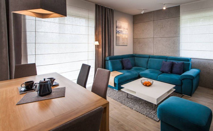 Lille stue-spisestue opsat turkis-sofa-træ-spisebord-brun-stole-belysning