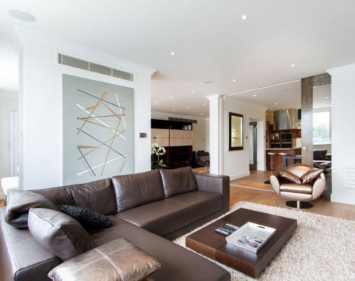 Valoisa olohuoneen sisustus minimalistiseen tyyliin ruskealla sohvalla