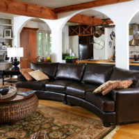 Tummanruskea sohva yksityisen talon olohuoneen sisustuksessa