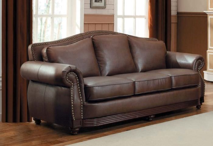 Tummanruskea sohva, jossa on aitoa nahkaa