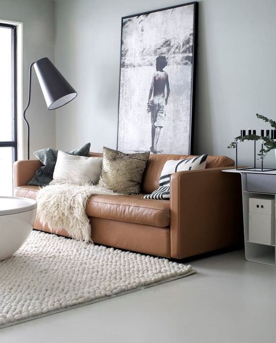 Interiér obývacího pokoje s hnědou pohovkou na světle šedé podlahové krytině