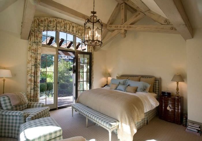 غرفة نوم ريفية على طراز بروفانس مع عوارض خشبية مكشوفة في السقف