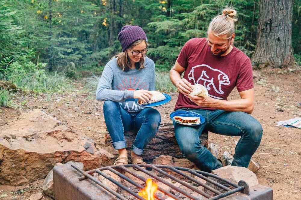 veganere nyder hjemmelavede fajitas foran et bål i skoven