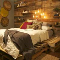 Seng på gamle paller i et rustikt soveværelse