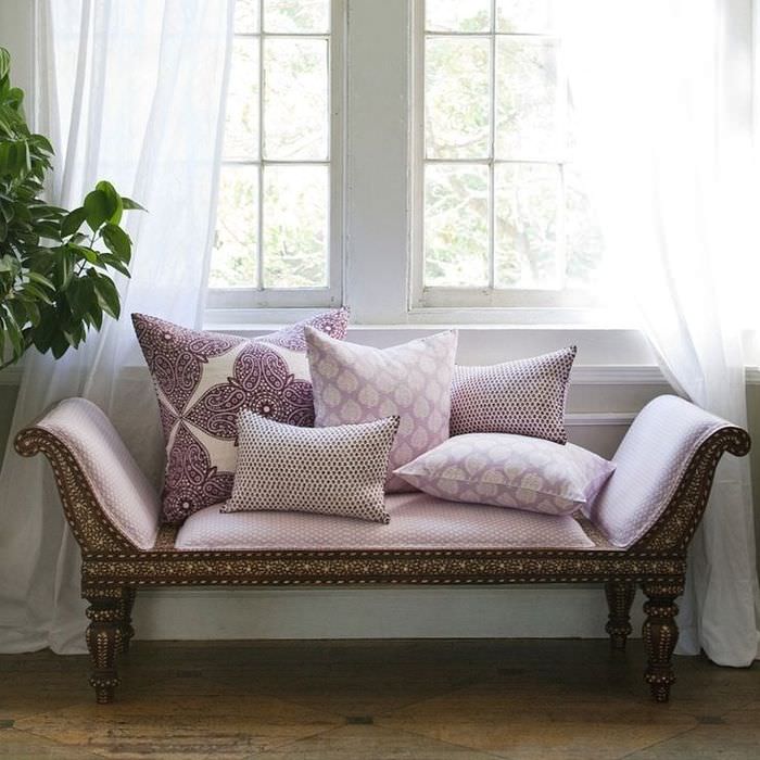 Stilfuld lavendelsofa foran vinduet i stuen