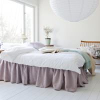 Hvitt soverom med lavendelteppe på sengen