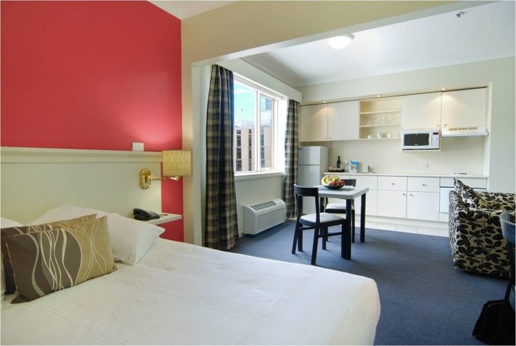 læse-lys-seng-moderne-soveværelse-væg-farve-rød-køkken-integreret-et-værelse-lejlighed