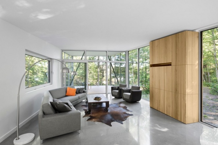 minimalistisk-levende-natur-moderne-hus-stue-beton-gulv-sofa-pels-tæppe-gulvlamper