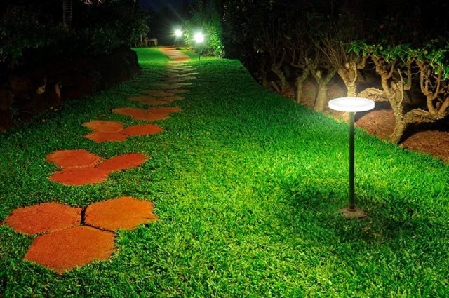 Havebelysning LED-PMMA spotlys oplyser trædesten med runde jordspyd havestier