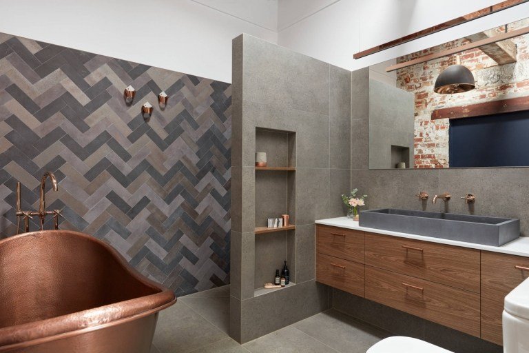 Moderne badeværelser med granitfliser og brusebad med fritstående badekar af håndvask i kobber