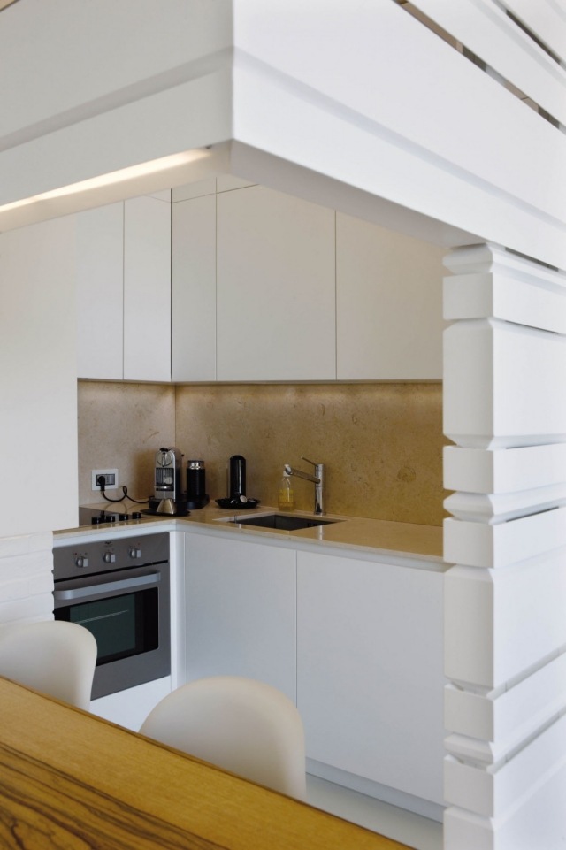 lille-køkken-hvid-håndtagsløse-fronter-natursten-bagvæg Moderne lejlighed