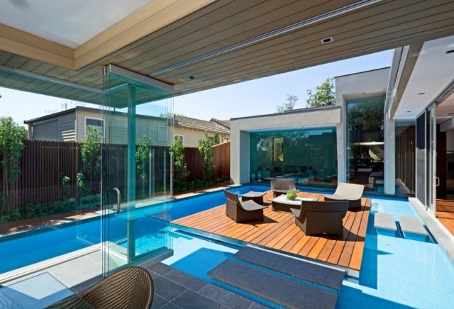 moderne hus træterrasse pool piedestal glas foldedøre granit trædesten