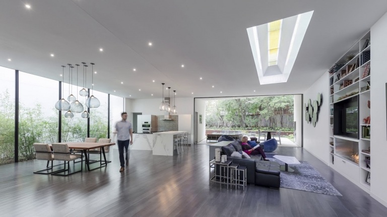Bæredygtig bygning af et moderne enfamiliehus ovenlysvinduer i stuen slipper mere sollys ind, rent energibesparende loftslamper om aftenen