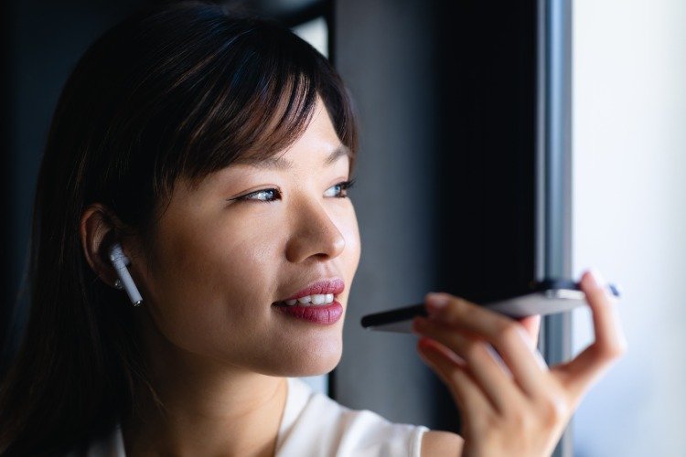 Smilende kvinde bruger håndfri telefon og bluetooth-hovedtelefoner med ikke-ioniserende stråling i tankerne