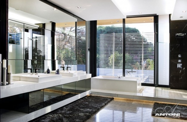 moderne badeværelse sort og hvidt underbord lyser stort vægspejl