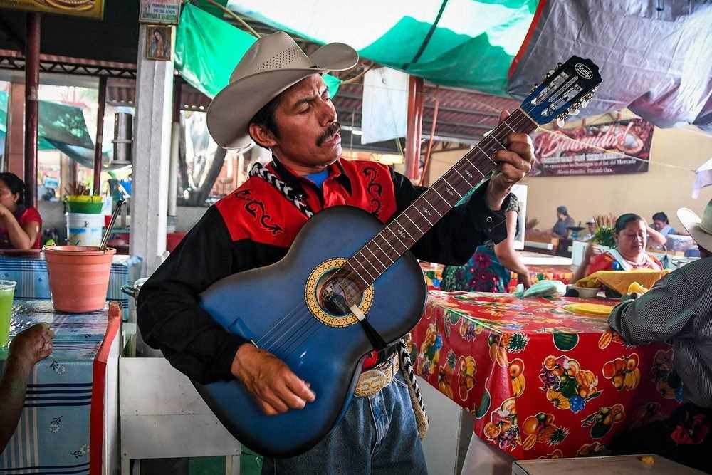 mexicansk sanger med guitar, der spiller musik i restaurant