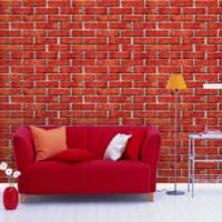 Röd soffa på en murad bakgrund