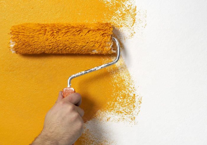 Malování tapety na zeď válečkem v oranžové barvě