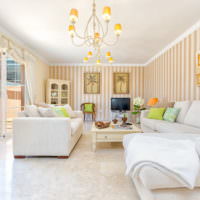 Bílý nábytek a světlé pruhy na tapetách v obývacím pokoji