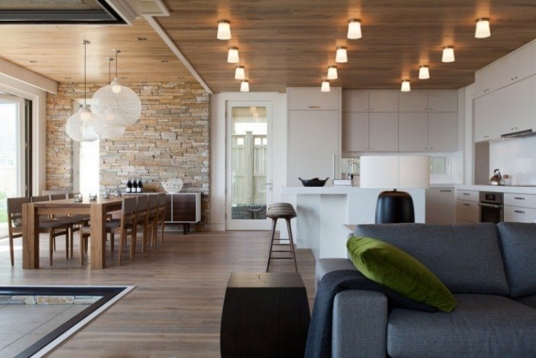 åbent-køkken-stue-lys-træloft-trægulv-sofa-grå-polstring-spisebord-massivt træ