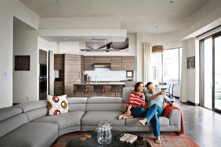 åbent-køkken-stue-køkken-tæller-brun-grå-hjørne-sofa-par-tæppe-accenter-vinduesvæg