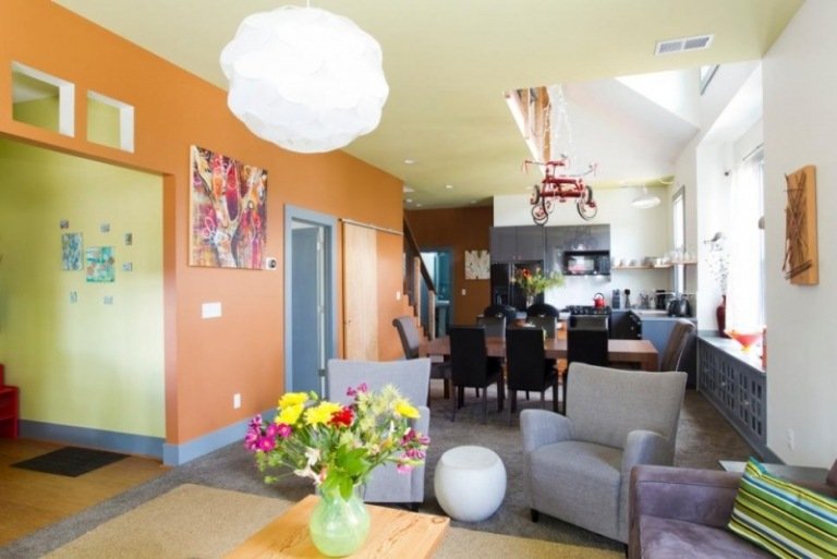 åbent-køkken-stue-orange-gul-grå-polstrede møbler-vase-blomster-farverige-interessant