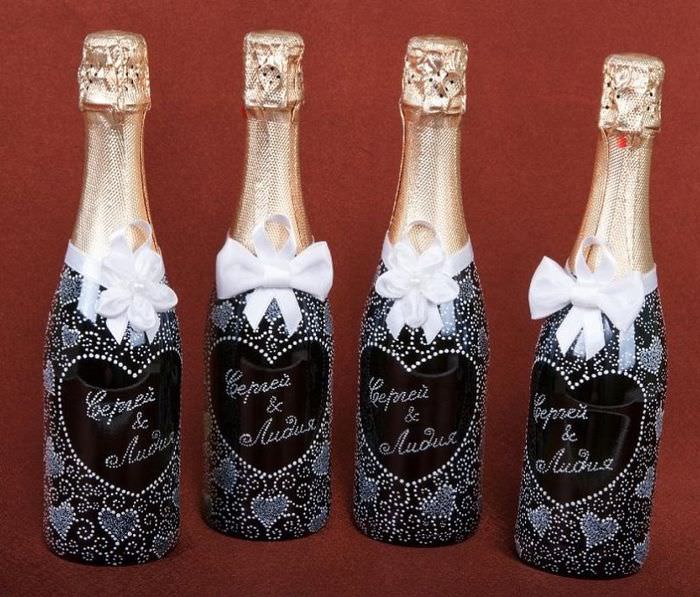 Champagneflaskor med namnen på de unga för bröllopet