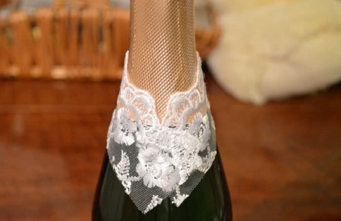 Spetsklistermärke på halsen på en flaska champagne för att dekorera en brud