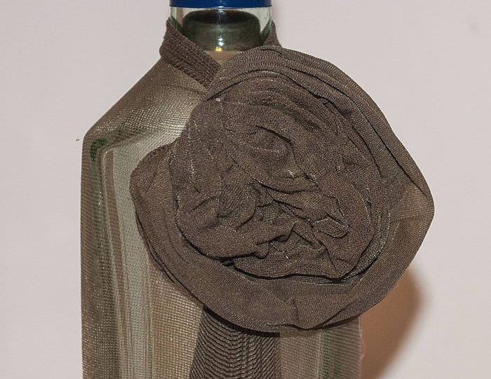 زهرة زخرفية من جوارب طويلة على قنينة زجاجية