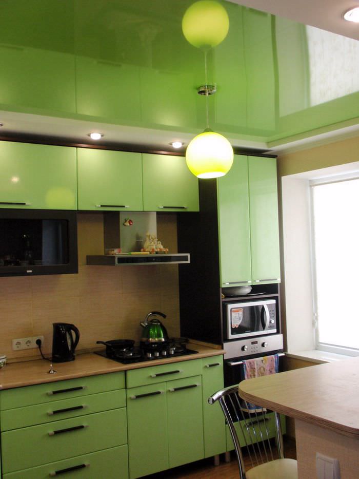 Огледален опънат таван в кухнята със зелен комплект