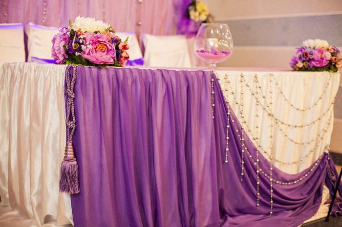Zdobenie okraja svadobného stola hrubou tkaninou
