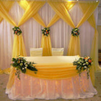 Gelbe und beige Stoffe in der Dekoration der Hochzeitstafel