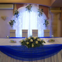 Blå tyll runt bröllopsbordets kanter