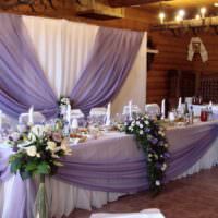 Kytice bielych ruží v rohoch svadobného stola