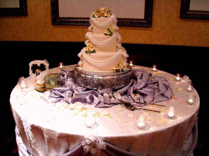 Hochzeitstorte auf einem Tisch umgeben von Kerzen