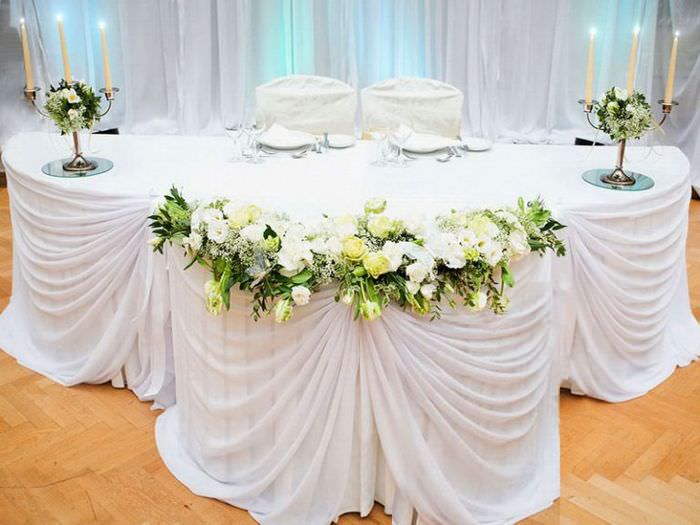 Hochzeitstafel mit weißem Dekotuch und Kerzenständern